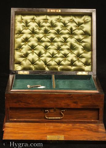 Figured walnut box with  a drawer concealed behind a hinged door, opening to a fitted plush interior with lift-out tray fitted for jewelry. The box has rounded ebony edges and a countersunk carrying handle to the top. Circa 1890.  Enlarge Picture